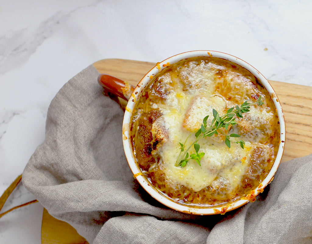 Herfstige groente gratin met spekjes en gesmolten kaas in een ovenbestendige pan, met broccoli en wortel