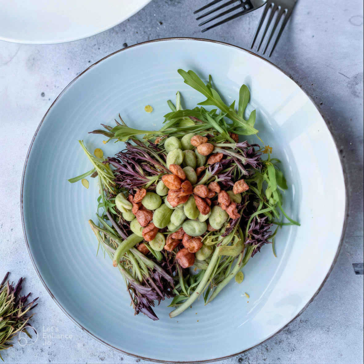 Tuinbonensalade met spekjes op een wit bord 
