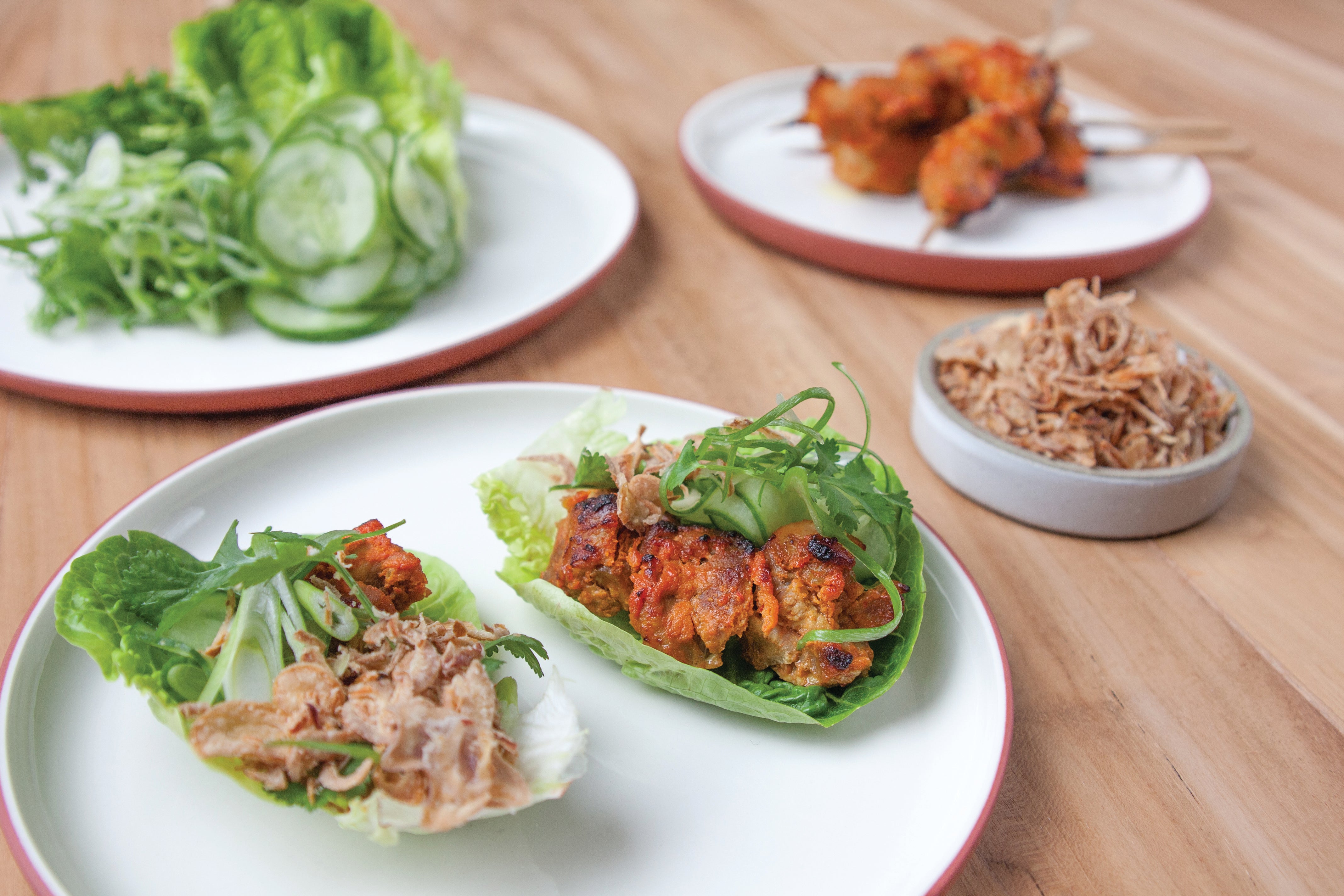 Gegrilde Surinaamse kipstukjes in baby Romaine bladeren met komkommersalade en gebakken uitjes — koolhydraatarm lunchrecept