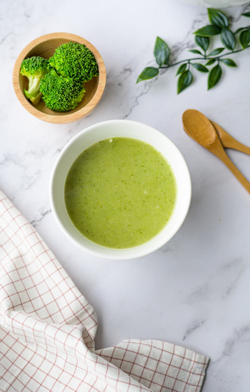 Romige broccolisoep met prei in een kom, gegarneerd met crème fraîche - koolhydraatarme groentesoep