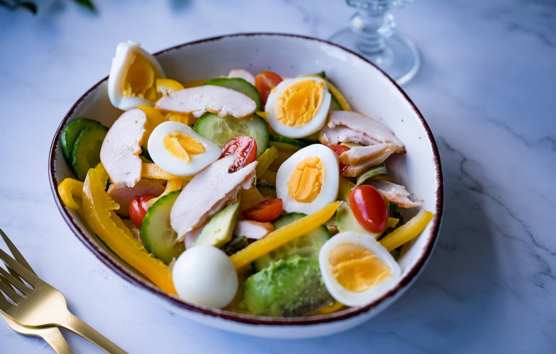 Simpele salade met gerookte kip, avocado, gekookt ei, paprika en snoeptomaten — koolhydraatarme lunch van Makkelijk Afvallen